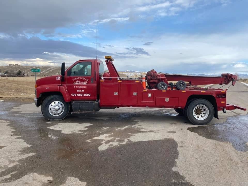 Red Turney Repair & Towing wrecker parked on a road outside Dillon, Montana